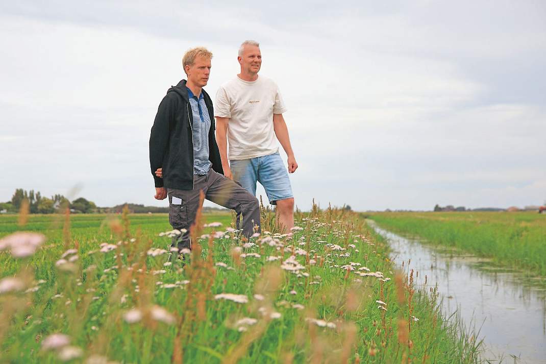 Harry van der Salm (l) en Martijn van den Berg kijken vanaf het land van Van der Salm uit over het perceel van de camping.
