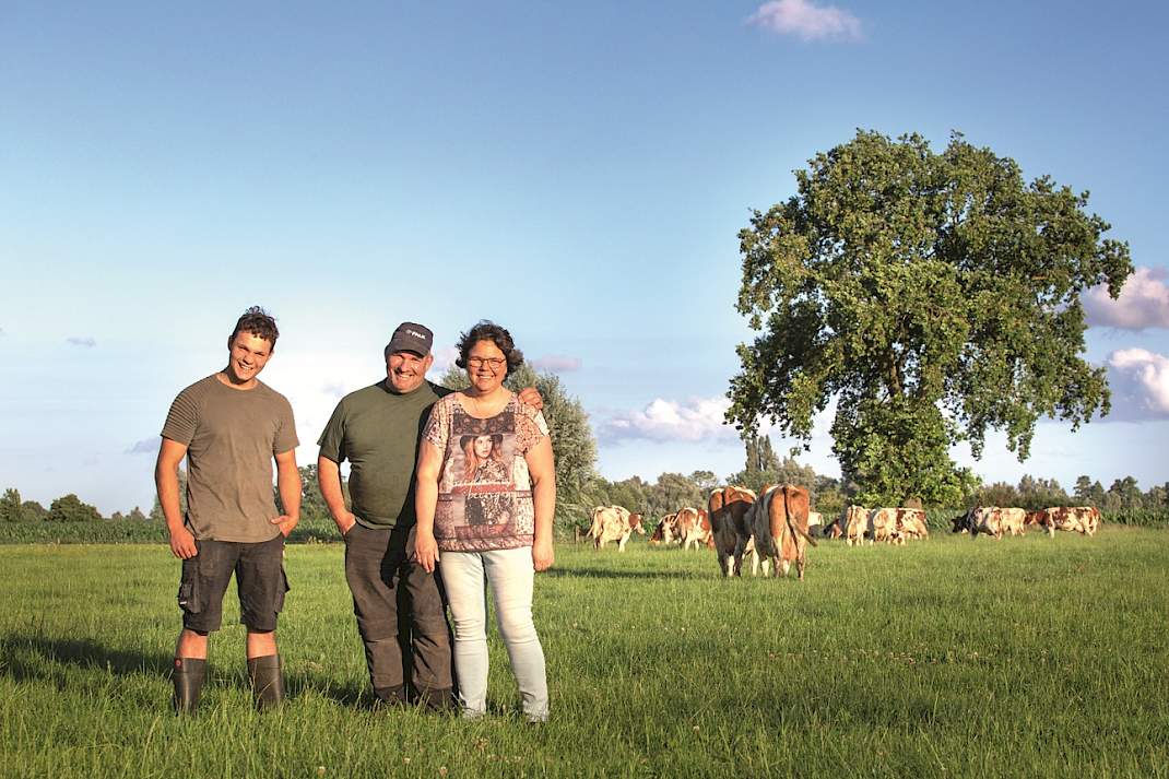 De familie Van Eek tussen de koeien in de wei