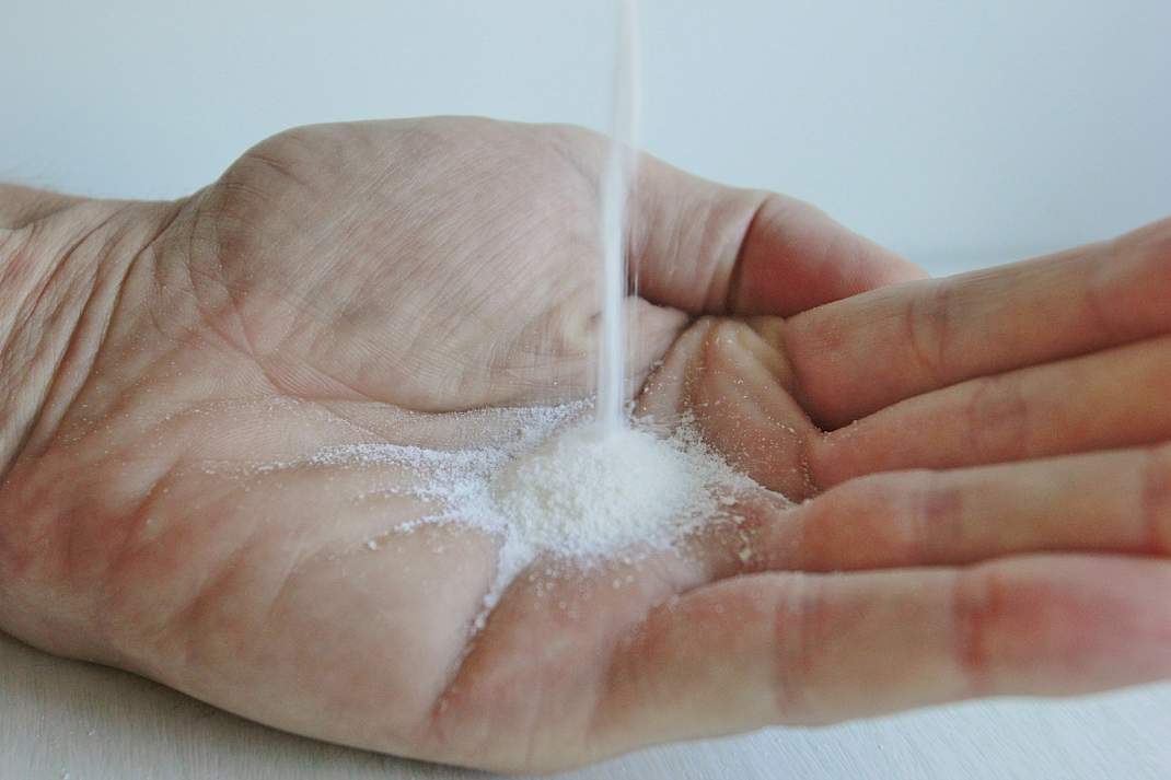 Een hand vang melkpoeder op