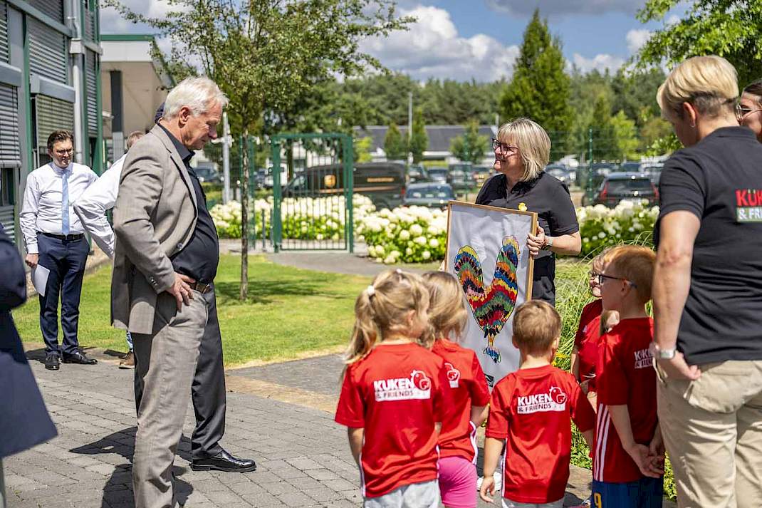 Het eigen kinderdagverblijf van het bedrijf, 'Kuikens en vrienden', overhandigde de minister een schilderij van een zelfgeschilderde kip.