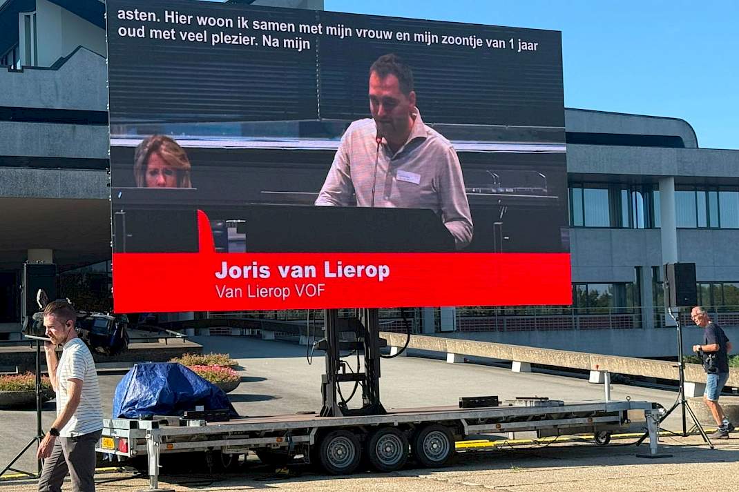 Groot beeldscherm buiten het provinciehuis toont Joris van Lierop tijdens zijn bijdrage