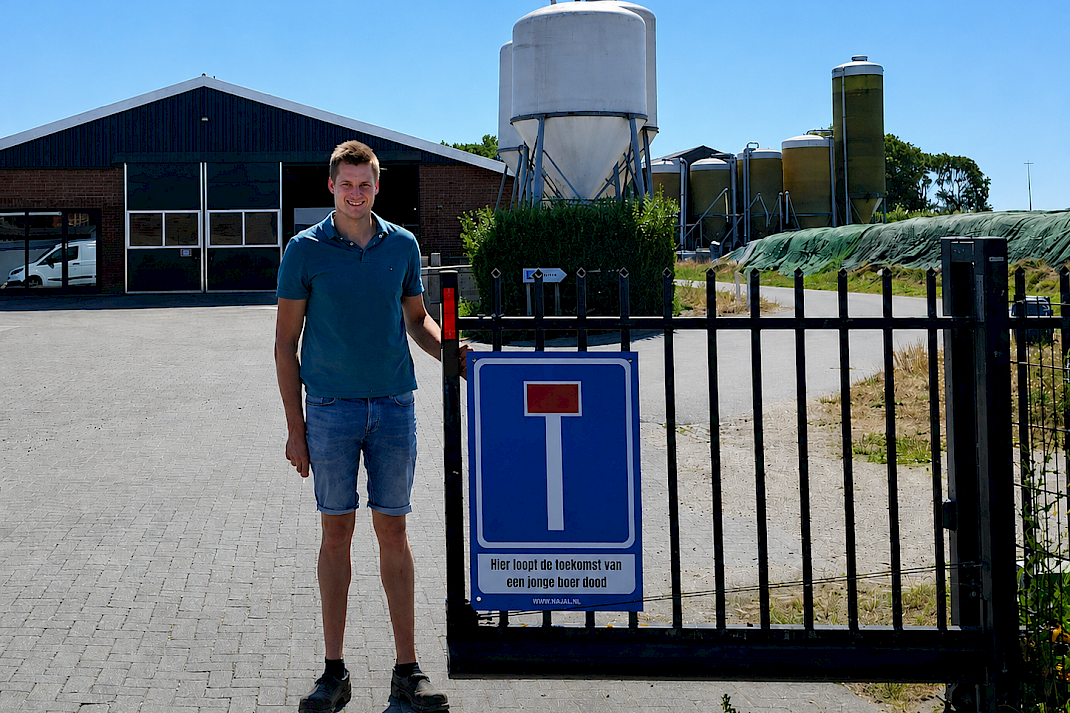 Een jonge boer naast het protestbord van de NAJK