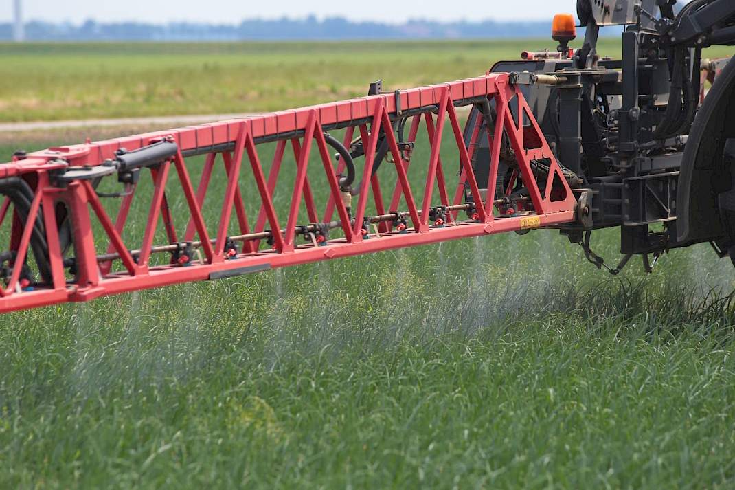 Spuitboom van veldspuit boven groen gewas