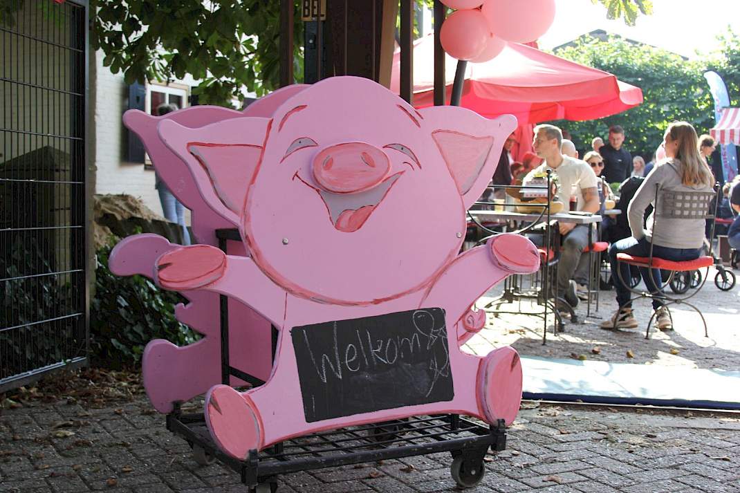 Twee mascottes van Weekend van het Varkens bij een varkensbedrijf