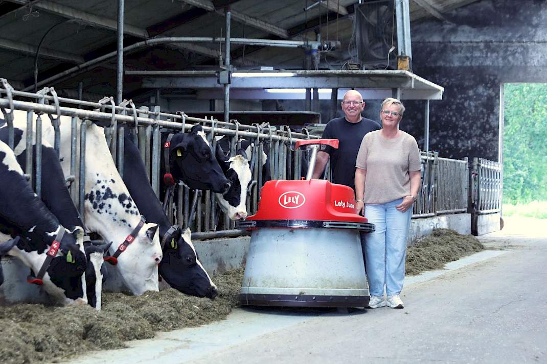 Melkveehouders bij een Lely Juno voeraanschuifrobot in een stal