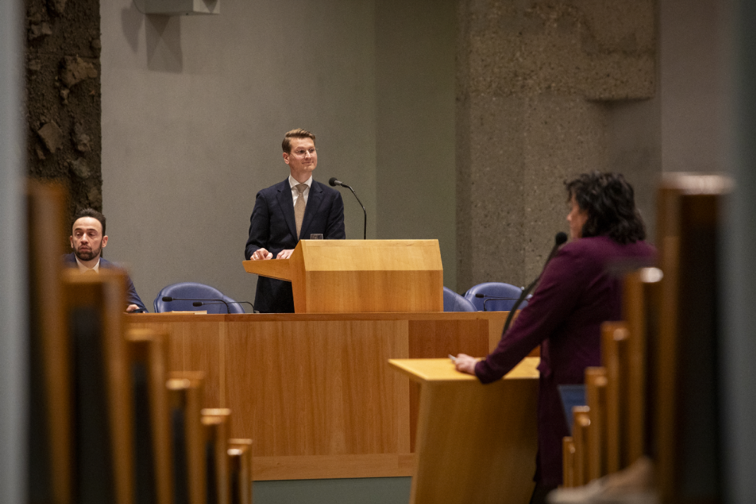 Minister Van Essen achter het katheder in de Tweede Kamer